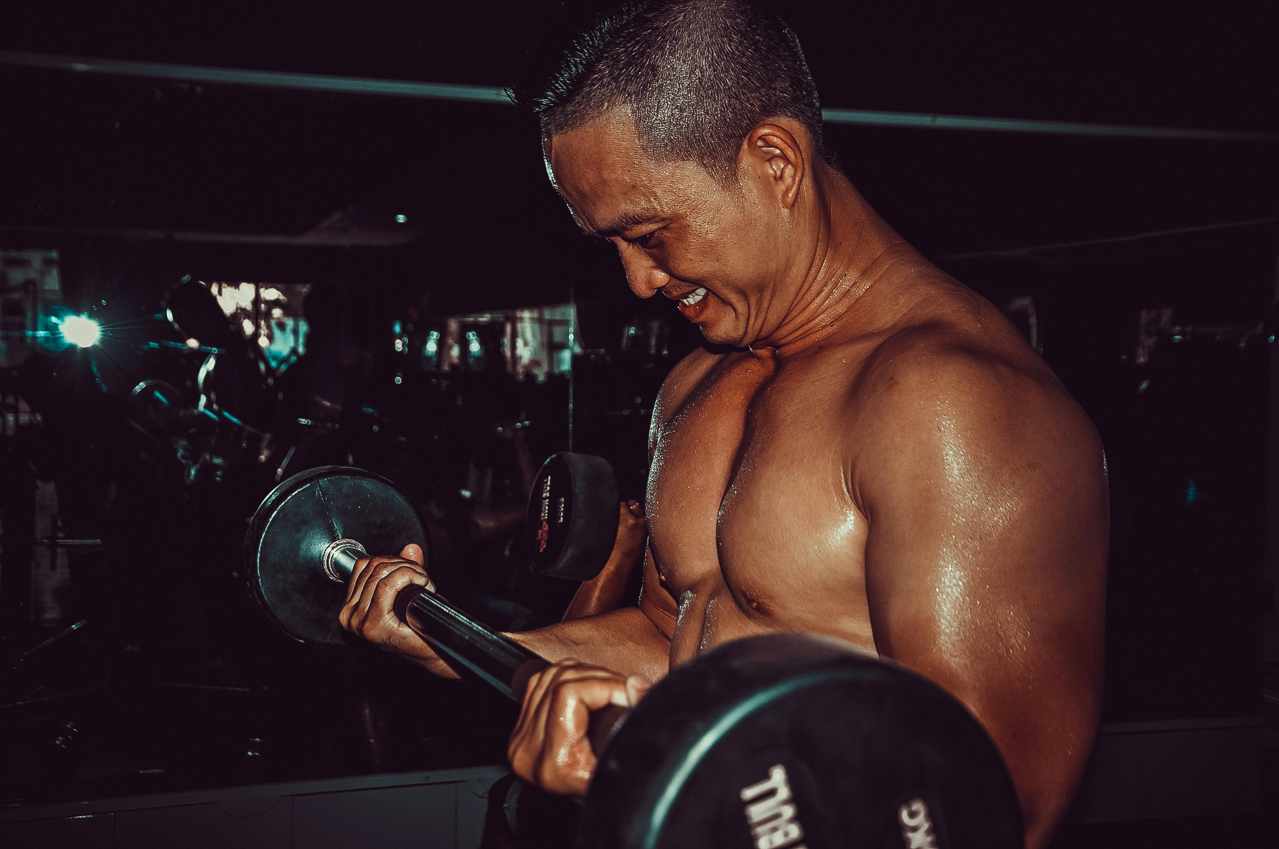 A determined man lifting a barbell in a gym, showcasing strength and fitness.
